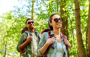 Image showing mixed race couple with backpacks hiking in forest