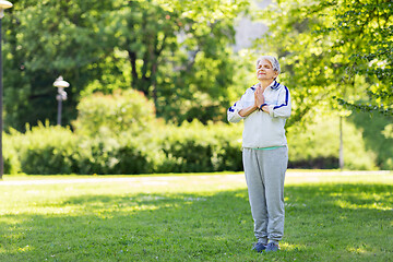 Image showing happy senior woman doing yoga at summer park