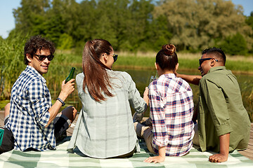 Image showing friends drinking beer and cider on lake pier