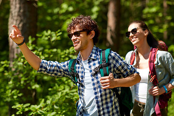 Image showing mixed race couple with backpacks hiking in forest