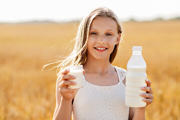 Image showing girl with bottle and glass of milk on cereal field