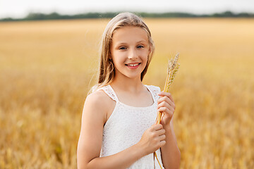 Image showing girl with spikelet of wheat on cereal field