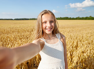 Image showing happy girl taking selfie on cereal field