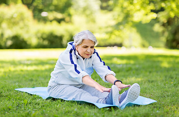 Image showing happy senior woman exercising at summer park