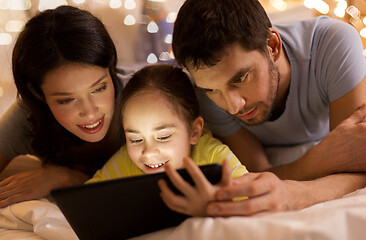 Image showing family with tablet pc in bed at night at home