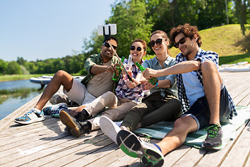Image showing friends with drinks taking selfie on lake pier