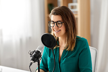 Image showing woman with microphone recording podcast at studio