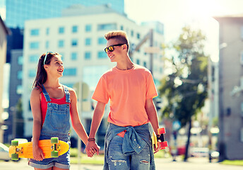 Image showing teenage couple with skateboards on city street