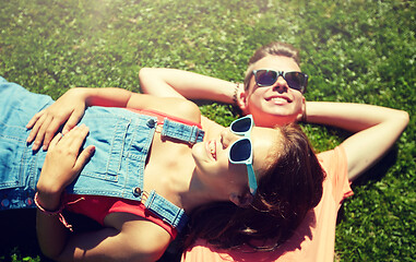 Image showing happy teenage couple lying on grass at summer