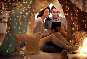 Image showing happy couple with tablet pc in kids tent at home