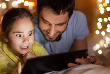 Image showing family with tablet pc in bed at night at home