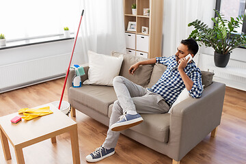 Image showing man calling on smartphone after cleaning home