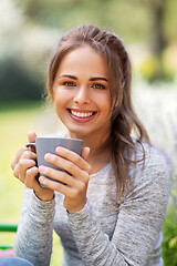 Image showing woman drinking tea or coffee at summer garden