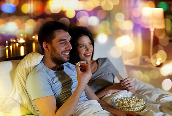 Image showing couple with popcorn watching tv at night at home