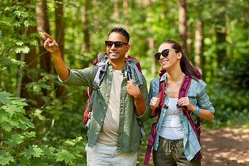 Image showing mixed race couple with backpacks hiking in forest