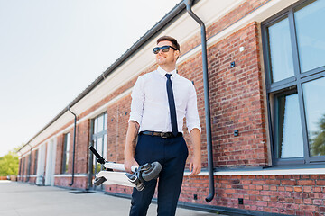 Image showing businessman with folding scooter on rooftop