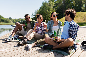 Image showing friends drinking beer and cider on lake pier