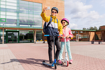 Image showing happy school kids with scooters taking selfie