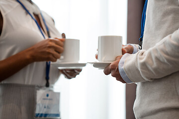 Image showing business people with conference badges and coffee