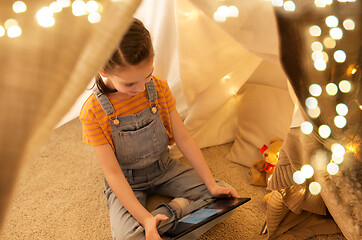 Image showing little girl with tablet pc in kids tent at home