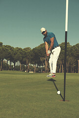 Image showing golf player hitting shot at sunny day