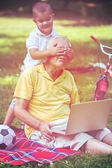 Image showing grandfather and child using laptop