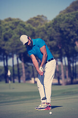 Image showing golf player hitting shot at sunny day