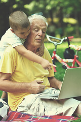 Image showing grandfather and child using laptop