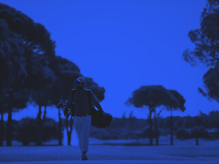 Image showing golf player walking and carrying bag