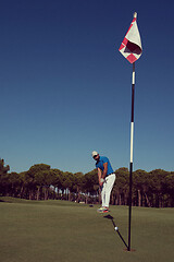 Image showing golf player hitting shot at sunny day