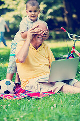 Image showing grandfather and child using laptop