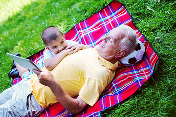 Image showing grandfather and child in park using tablet