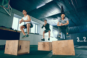 Image showing Group of sporty muscular people are working out in gym.