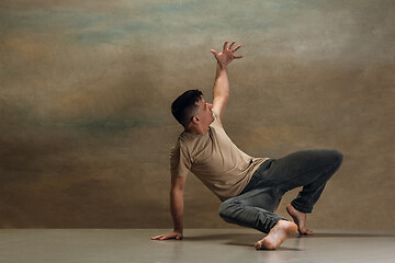 Image showing The young man dancing on gray