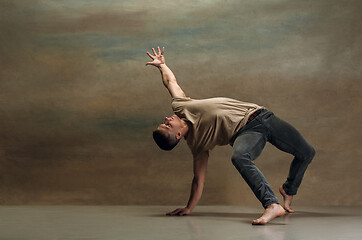 Image showing The young man dancing on gray