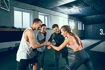 Image showing Image of group of sporty muscular people are having rest after working out in gym.