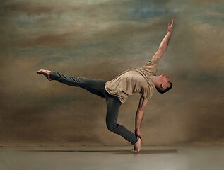 Image showing The young man dancing on gray