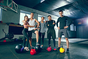 Image showing Portrait of young people resting and looking at camera after training session in gym.