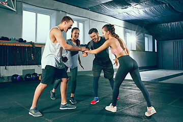 Image showing Image of group of sporty muscular people are having rest after working out in gym.