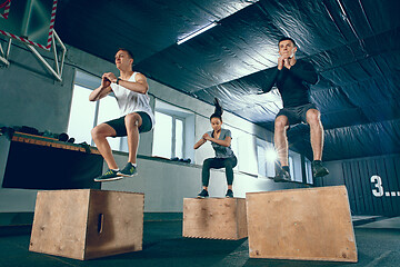 Image showing Group of sporty muscular people are working out in gym.