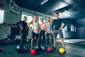 Image showing Portrait of young people resting and looking at camera after training session in gym.