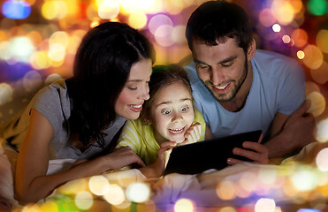 Image showing family with tablet pc in bed at night at home