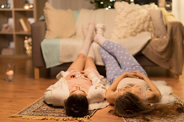 Image showing female friends lying on floor at home pajama party