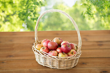 Image showing ripe apples in wicker basket on wooden table