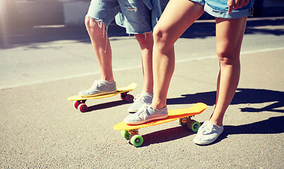 Image showing teenage couple riding skateboards on city street