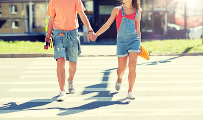 Image showing teenage couple with skateboards on city crosswalk