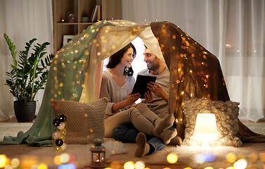 Image showing happy couple with tablet pc in kids tent at home