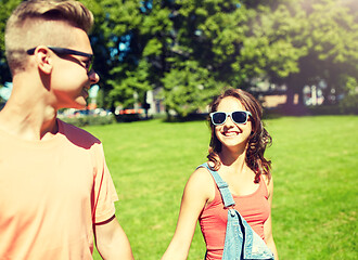 Image showing happy teenage couple walking at summer park