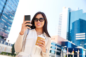 Image showing smiling woman with smartphone and coffee in city