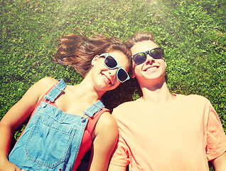 Image showing happy teenage couple lying on grass at summer